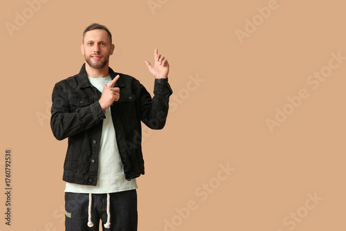 Smiling young man pointing ...