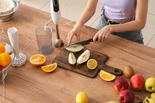 Young woman cutting fresh p...
