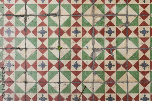 Seamless mosaic pattern of old Peranakan floor tiles in George Town, Penang, Malaysia, showing a geometric motif in red, green, and cream tones.