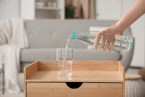 Young woman pouring water f...