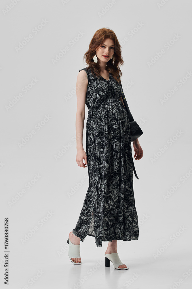 Fototapeta premium A girl model in stylish clothes poses on a gray background.