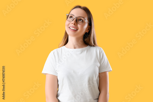 Dreamy young woman on yello...
