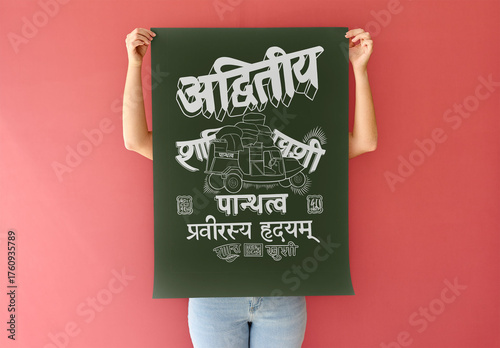 Mockup of woman holding a blank A2 poster against a red wall