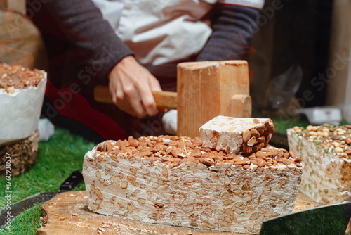 Cutting Traditional Nougat With Almonds At Market Stall