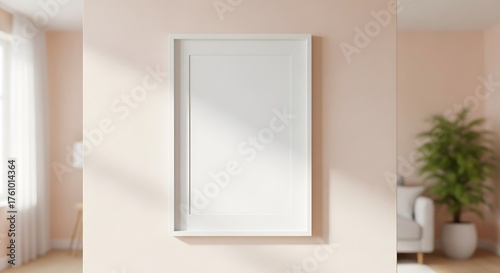 Blank White Picture Frame Mounted on a Soft Pink Wall With Natural Light Streaming Through a Nearby Window and Green Plant in Background