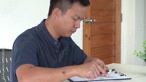 Young asian businessman is suffering pain on wrist, finger and arm, arthritis inflammation while working and he is massaging himself and doing exercise with his hands to relax and to relieve pain.	
