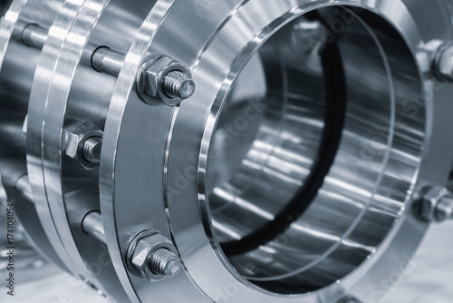 Fotografi Stainless steel shiny rings connected with long bolts as part of industrial pipi