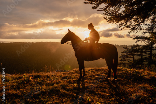 Silhouette of a Horse and Rider at Sunset in the Mountains