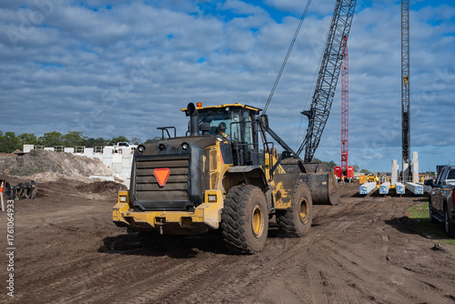 large front loader tractor and cranes at highway construction site