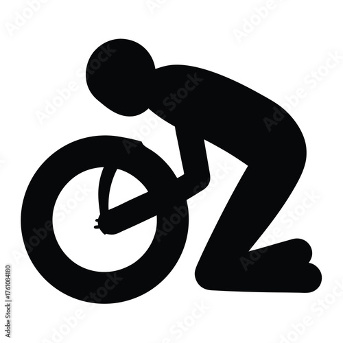 A silhouetted figure repairs or maintains a bicycle wheel on the ground