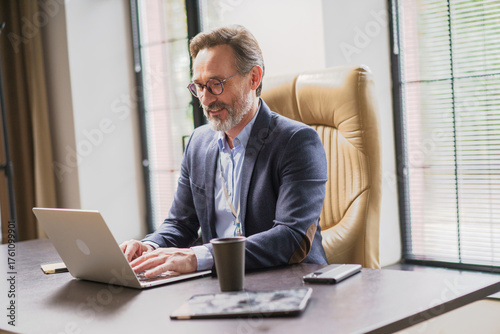 A Businessman is Focused on His Work While Functioning Remotely in a Modern Office