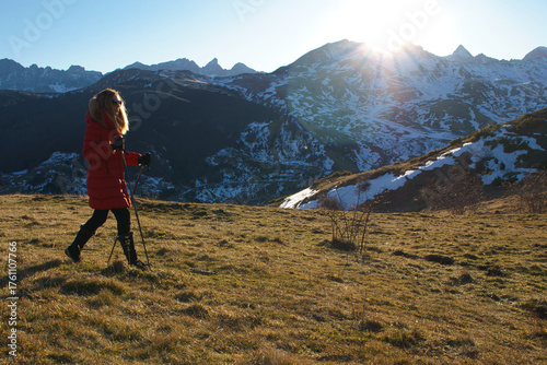 Woman hiking mountain path enjoying winter sun