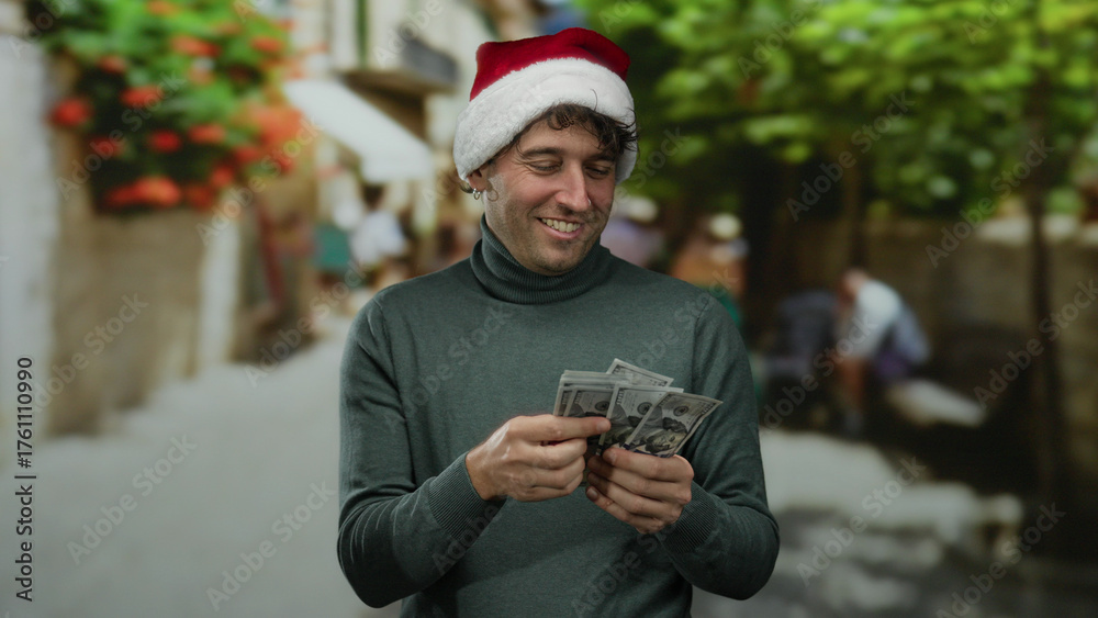 Obraz premium Hispanic man in christmas hat counting american dollars outdoors on a festive street, smiling joyfully surrounded by warm holiday ambiance.