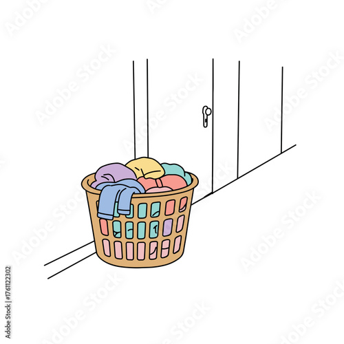 Colorful laundry basket filled with clean clothes in hallway  