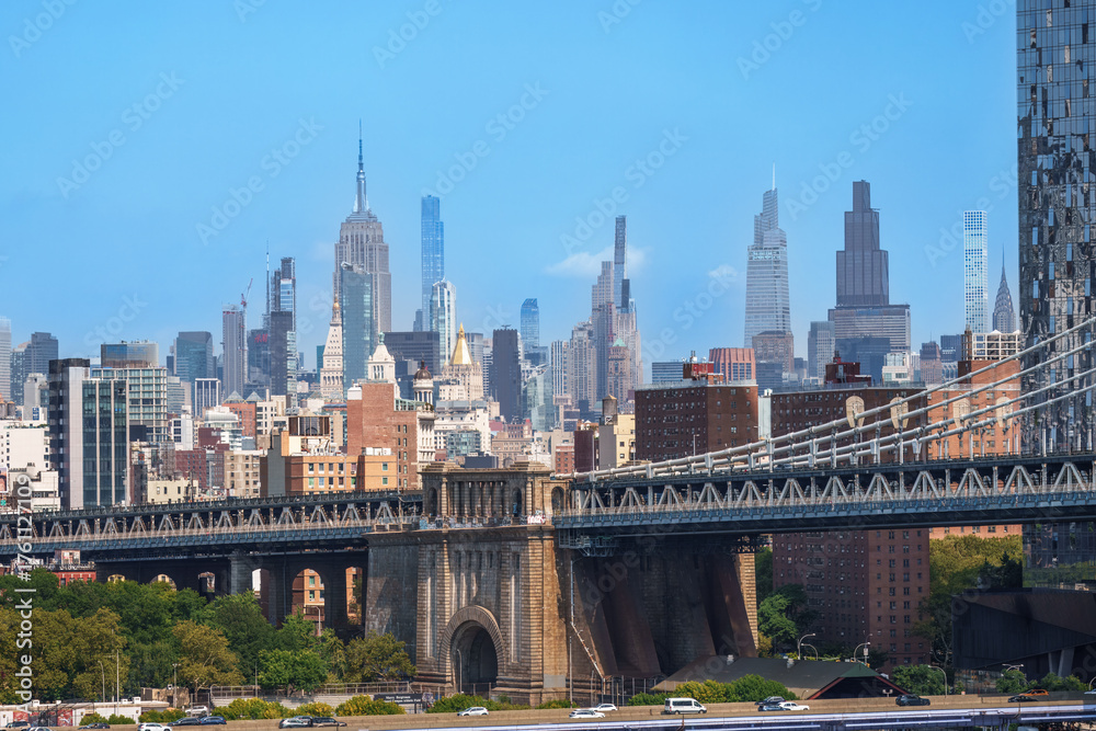 Obraz premium Majestic Brooklyn Bridge graces the NYC skyline. Soaring steel arches frame the cityscape, bathed in warm sunlight. Iconic landmark for travel and architecture projects. wallpaper, 4k 
