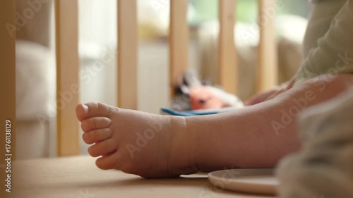 The feet of a tiny baby in a crib convey the innocence and joy of early childhood, highlighting the beauty of often overlooked moments in life and development