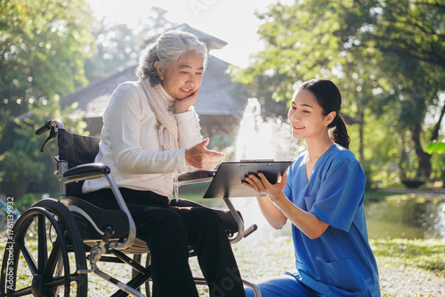 A woman in a wheelchair is being assisted by a woman in a blue shirt