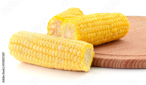 Boiled corn cobs on wooden board close-up