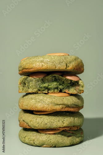 Stack of green cookies with creamy filling on a soft background featuring copy space
