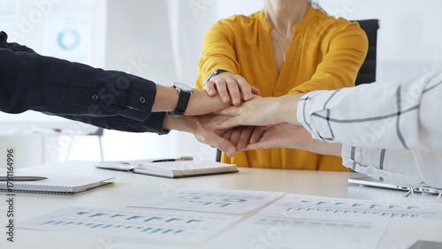 Billede på lærred Business people team joining hands over workplace documents, symbolizing collabo