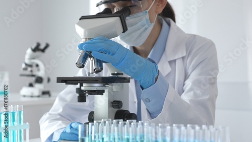 Schilderij op canvas A scientist in protective gear adjusts a microscope lens and accurately analyzes medical research samples in a sterile laboratory environment