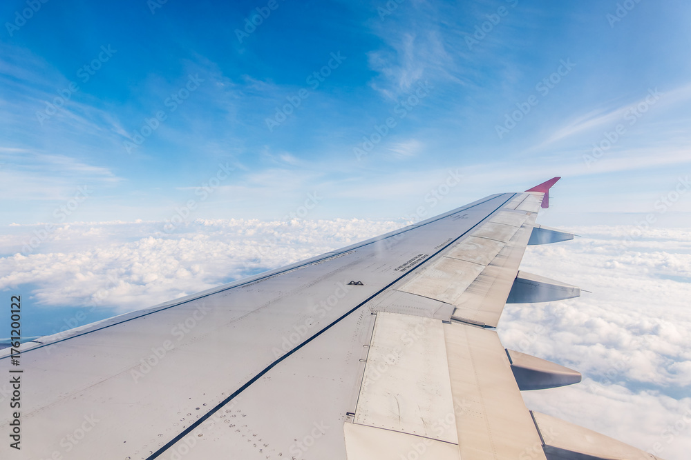 Obraz premium View from the airplane window at a beautiful cloudy sky and the airplane wing