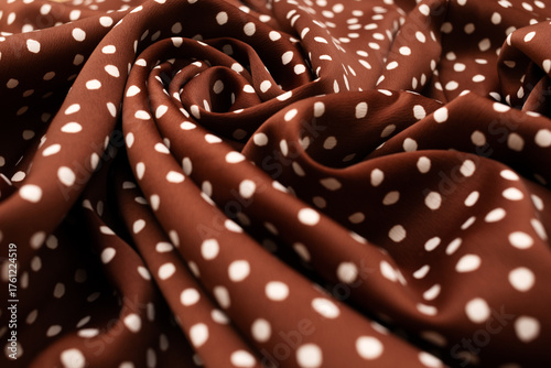 Vászonkép Close-up of terracotta colored silk fabric with white polka dots, softly draped to create an abstract background