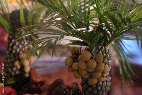 Fresh longan fruit served with pineapple is served with a tropical-themed ornament design.