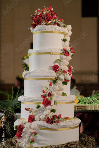 A large wedding cake with luxury decorations represents the splendor of the event for a happy couple.