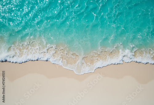 aerial view of ocean waves gently washing over a pristine sandy shoreline depicting serene beach