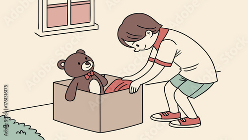 A boy packing a teddy bear and red cloth into a cardboard box near a window and some green bushes