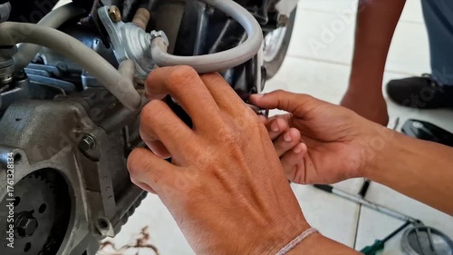 Hands of Vocational Student Mechanic Repairing Motorcycle Engine