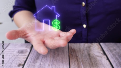 Financial management in the real estate sector. Close-up of a person's hand sitting at a table holding a virtual icon of a house with a money sign.