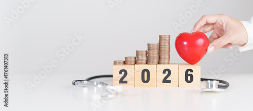 Happy New Year 2026 with doctor Stethoscope, coins stack and red heart on table. health care, Money saving, Goal, Resolution, health Insurance, Wellness and medical concept