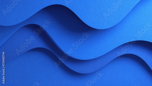 Curved layers of textured blue paper forming a spiral abstract pattern with smooth gradients and dramatic light and shadow play.