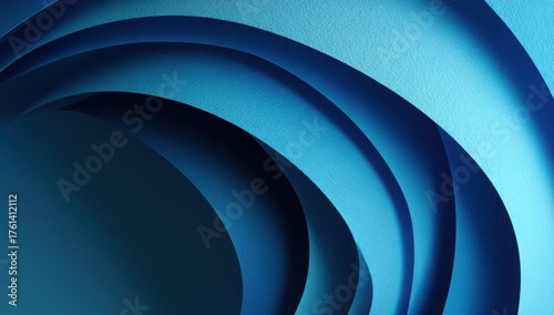Curved layers of textured blue paper forming a spiral abstract pattern with smooth gradients and dramatic light and shadow play.