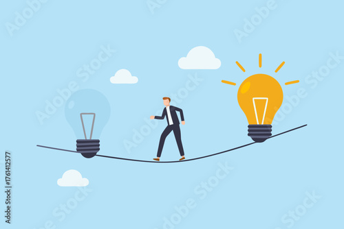 Businessman walking on a tightrope between a lit and unlit lightbulb symbolizing idea generation and innovation