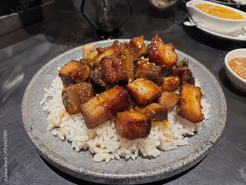 A popular Filipino dish featuring succulent, caramelized pork belly chunks served over fragrant garlic rice, creating a perfect blend of savory and slightly sweet flavors.