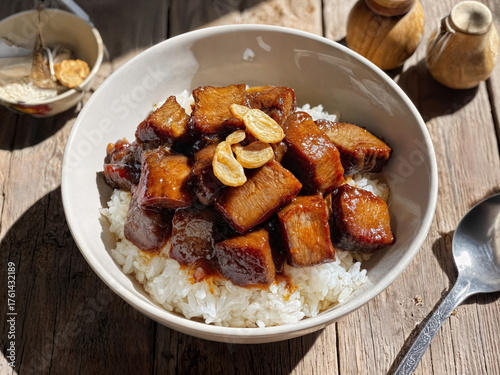 An appetizing dish with boiled rice, juicy chopped square meat and fresh garlic. Asian cuisine in an exquisite presentation.