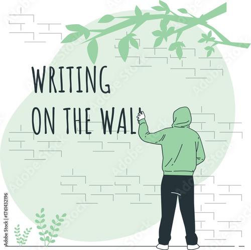 Person in hoodie writing on a brick wall with text WRITINGONTHEWAL writing on the wall