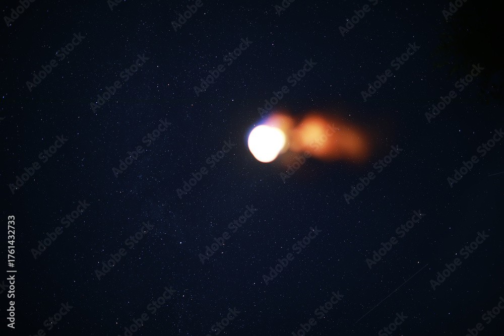 Fototapeta premium Blurry Rocket Launch in Starry Night Sky with Fiery Trail
