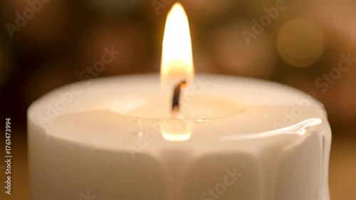Mesmerizing close-up of a single candle's flame dancing over melting wax with a warm, glowing bokeh background.