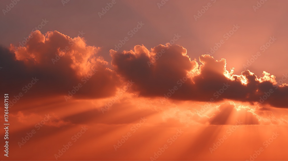 Fototapeta premium Dramatic sunset clouds glowing orange with beams of light shining down