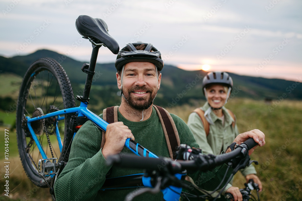 Naklejka premium Couple cycling together in nature, smiling and enjoying outdoor adventure.