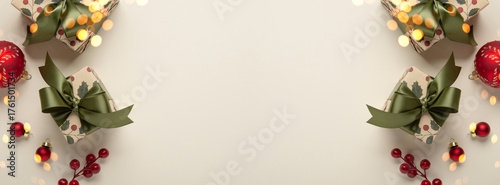 Merry Christmas and Happy Holidays greeting card, frame, banner. New Year. Christmas ornaments and gifts, presents on light beige background top view. Winter xmas holiday festive theme.