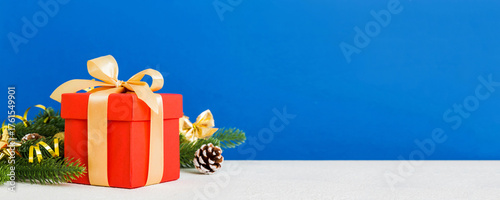 New Year Christmas mood, gift box, branches of a christmas tree, New Year decorations on a colored background