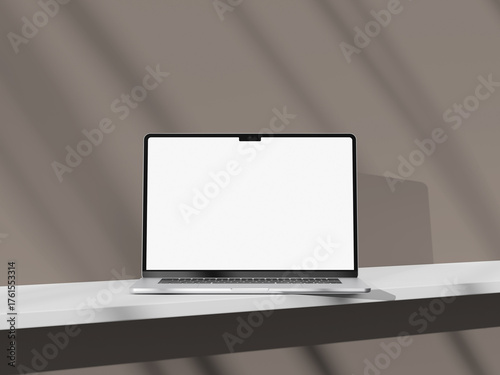 Stylish silver laptop on a light-colored desk with an empty screen display.