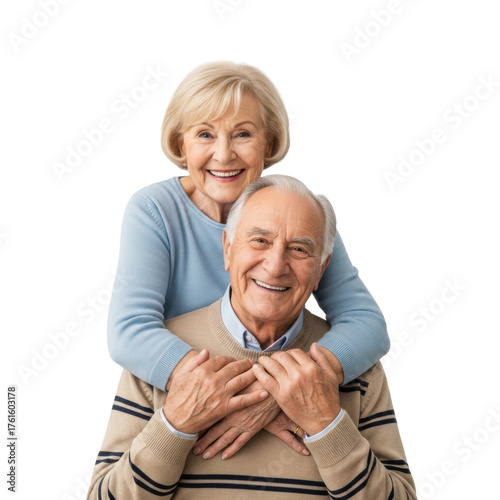 Elderly caucasian woman with blonde hair embracing older caucasian man with gray hair from behind, both smiling at camera in transparent studio with copy space. Concept of healthy aging and loving