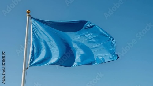 Blue flag is waving against a blue sky background