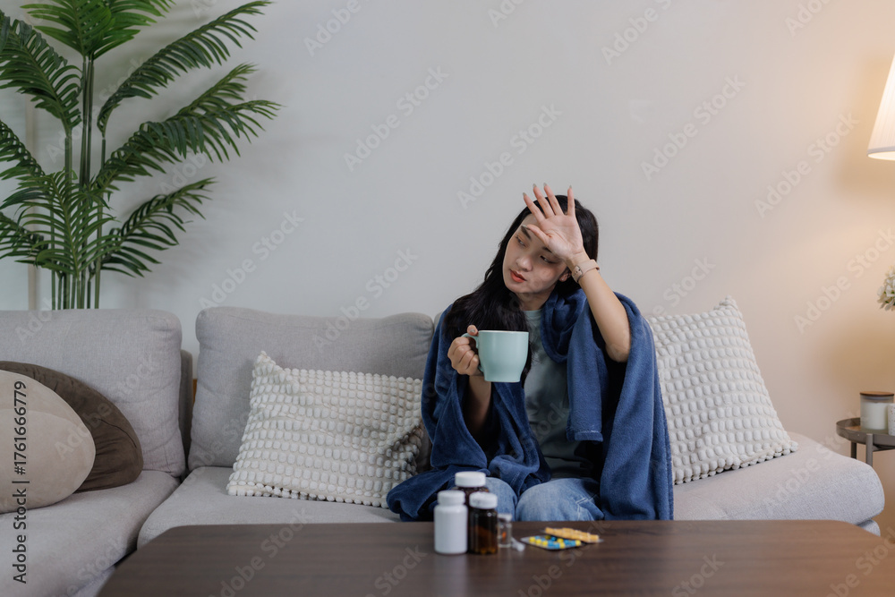 Obraz premium Woman feeling unwell having fever on a sofa